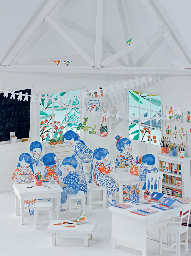 Children's classroom with white walls, desks, and colorful illustrations of children at work.