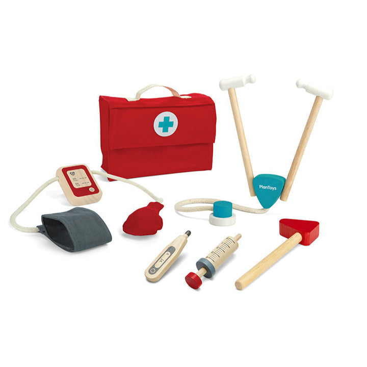 Plan Toys brand Set of toy medical tools including a red first aid kit on a white background