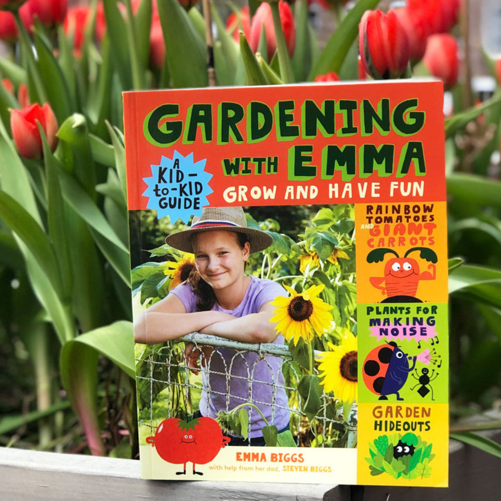 Book titled 'Gardening with Emma' in front of red tulips