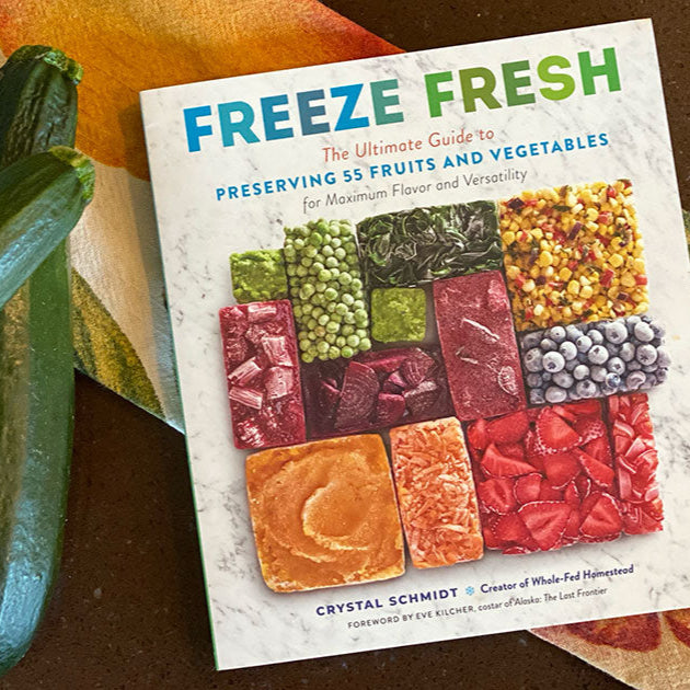 Book titled 'Freeze Fresh' with zucchinis on a brown surface