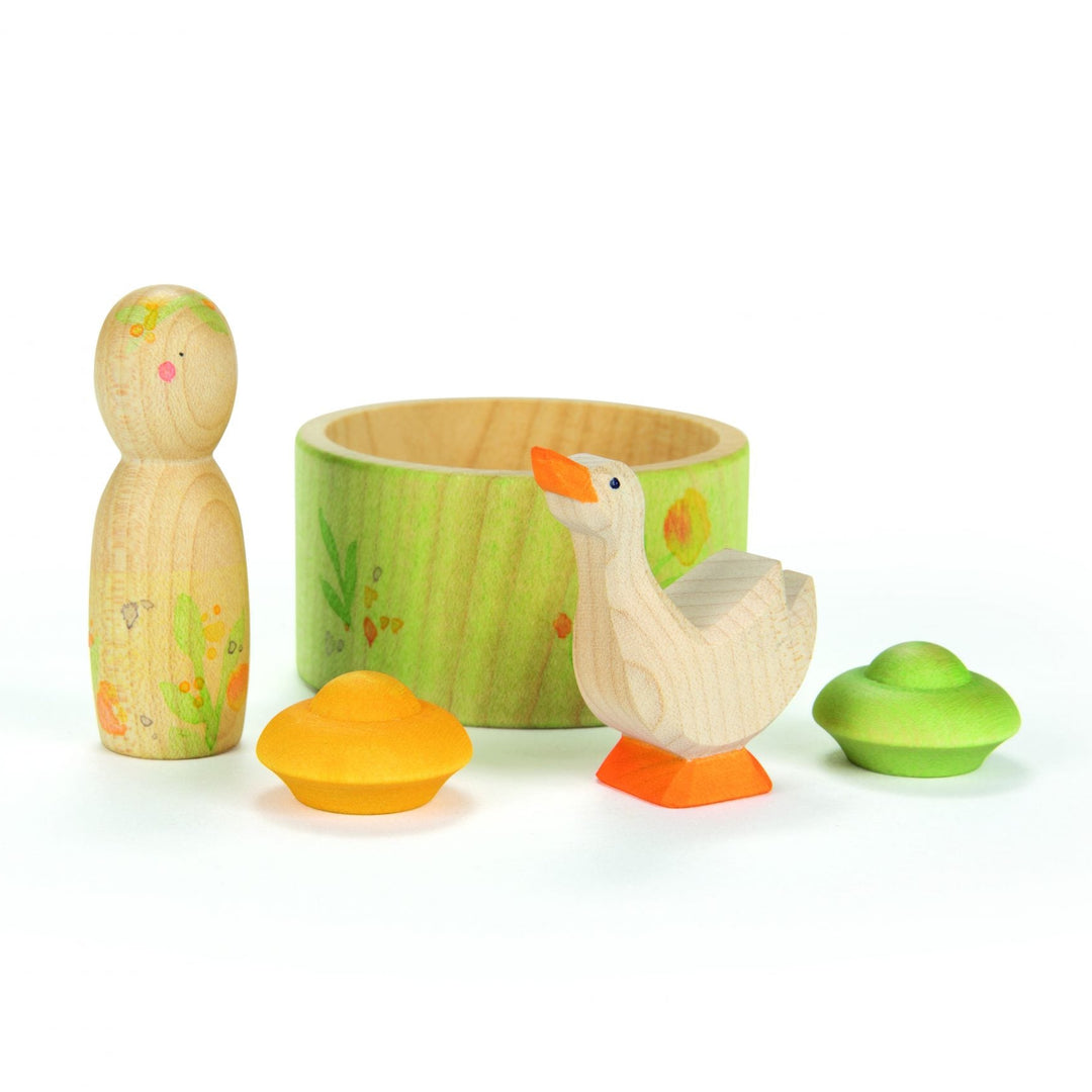 Set of wooden duck toys with a green container on a white background