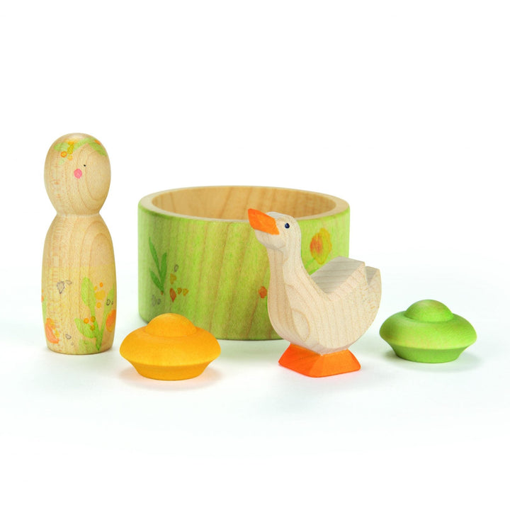 Set of wooden duck toys with a green container on a white background