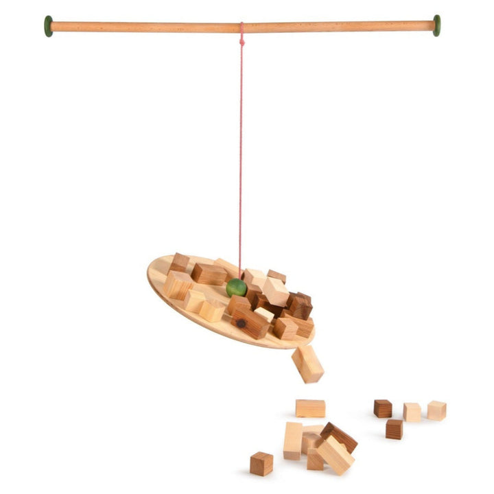 A balance board with a collection of wooden pieces attached to a string, meant for educational or therapeutic use.