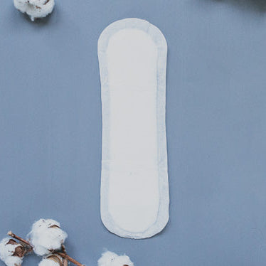 White NatraCare sanitary pad on a blue background with cotton flowers
