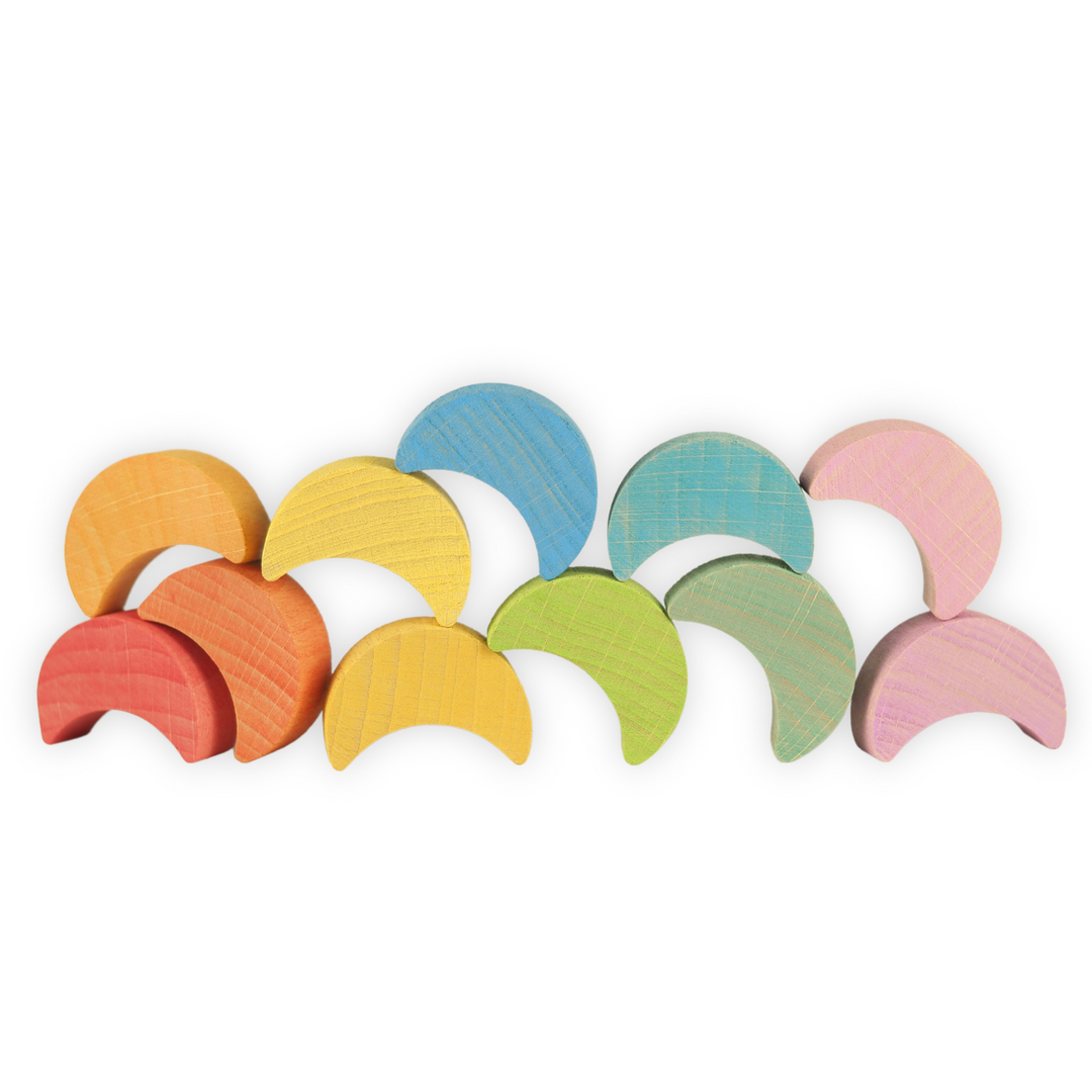 Set of colourful Ocamora brand wooden rainbow moons on a white background/