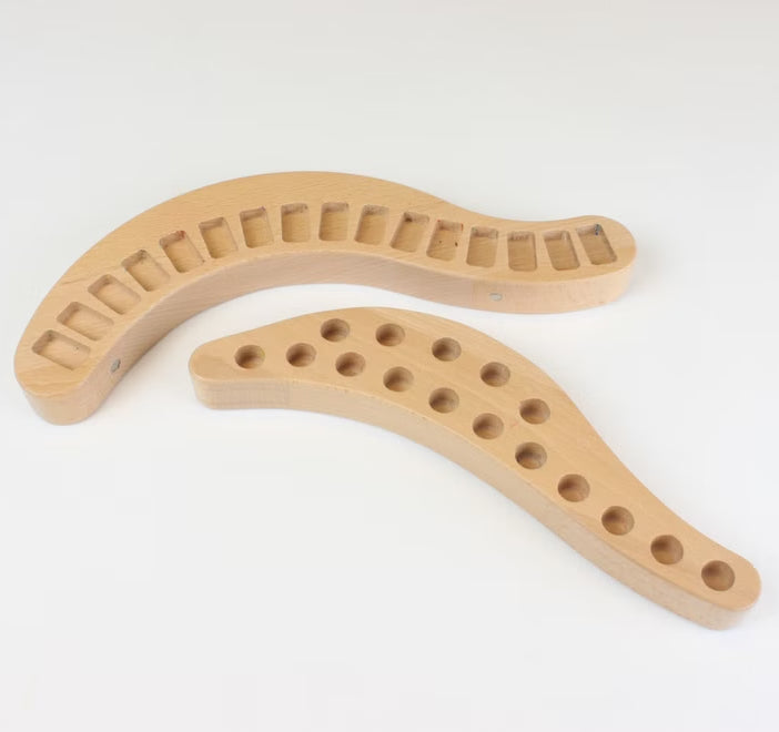 Two wooden arch-shaped crayon holders with holes on a white background