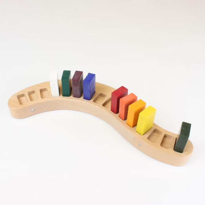 Wooden crayon holder with colourful Stockmar wax block crayons on a white background