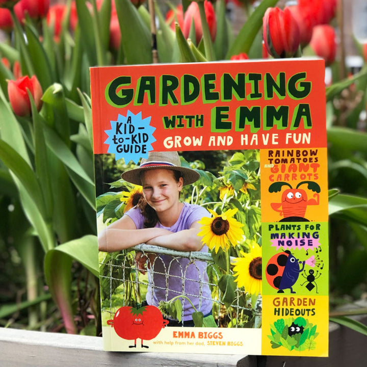 Book titled 'Gardening with Emma' in front of red tulips