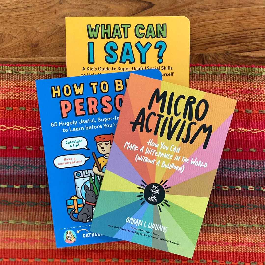 Three books on a colorful woven surface