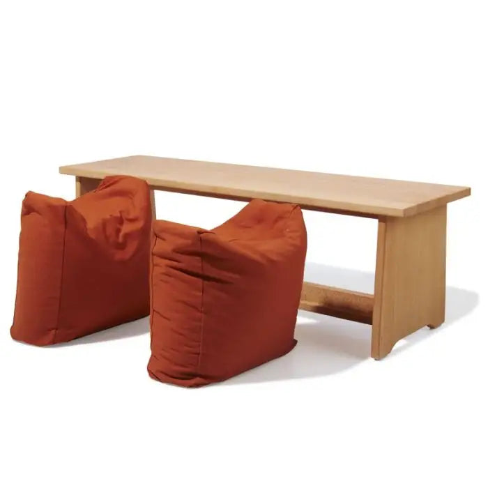 Wooden table with two orange cushions on a white background