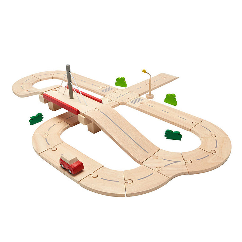 Plan Toys wooden road set with a red vehicle on a white background