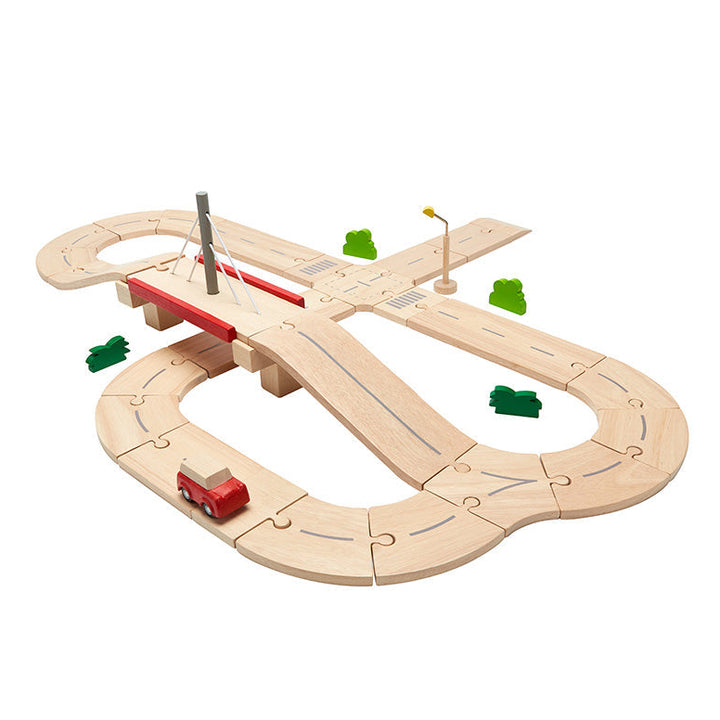Plan Toys wooden road set with a red vehicle on a white background