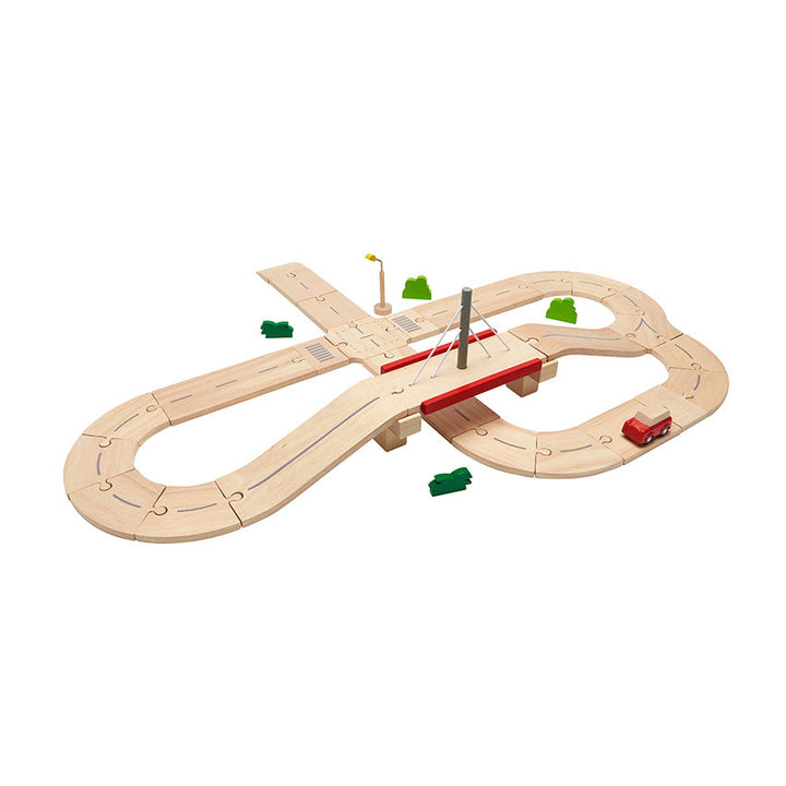 Plan toys wooden road track set with a red car on a track on a white background