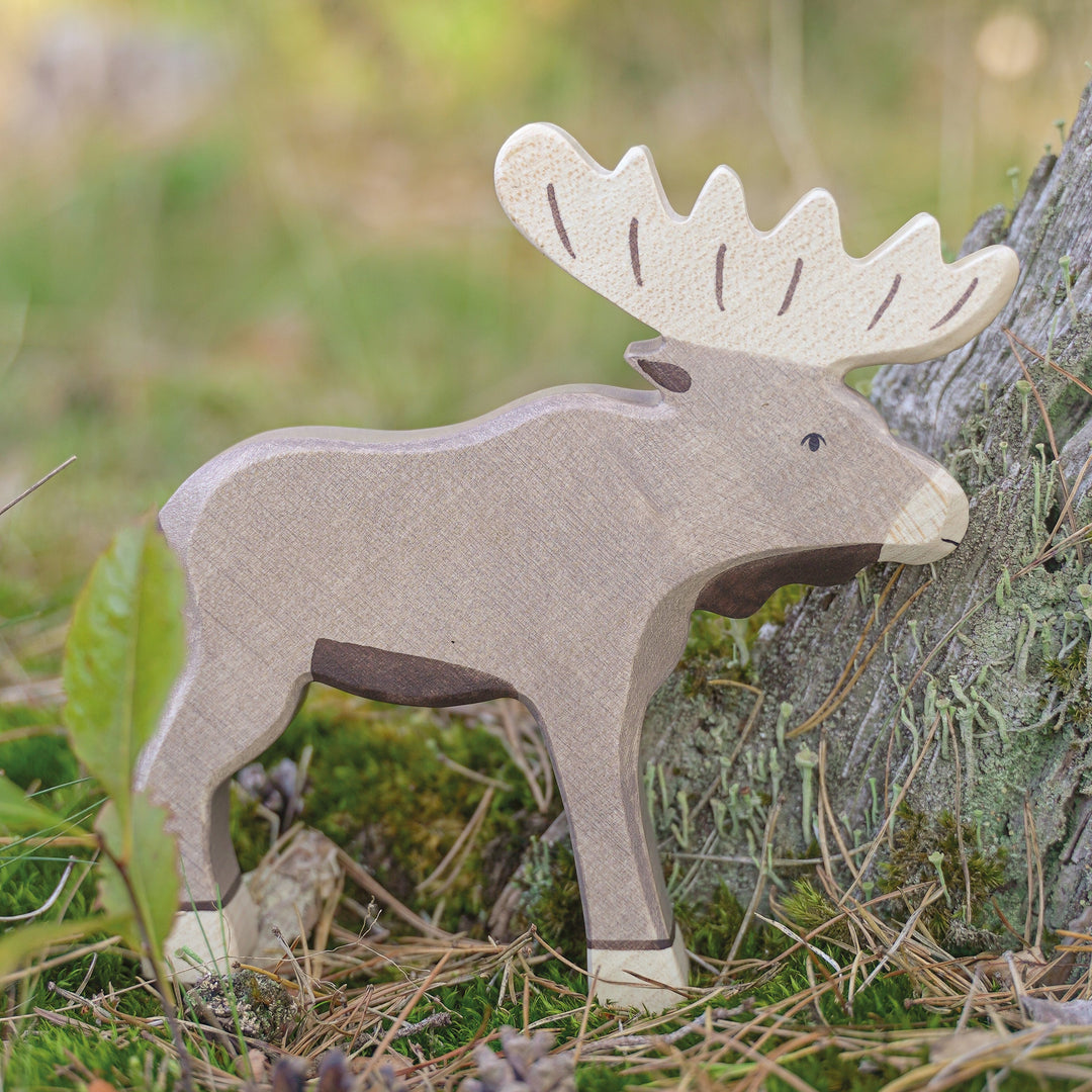 Holztiger wooden moose toy figurine in a natural setting with greenery