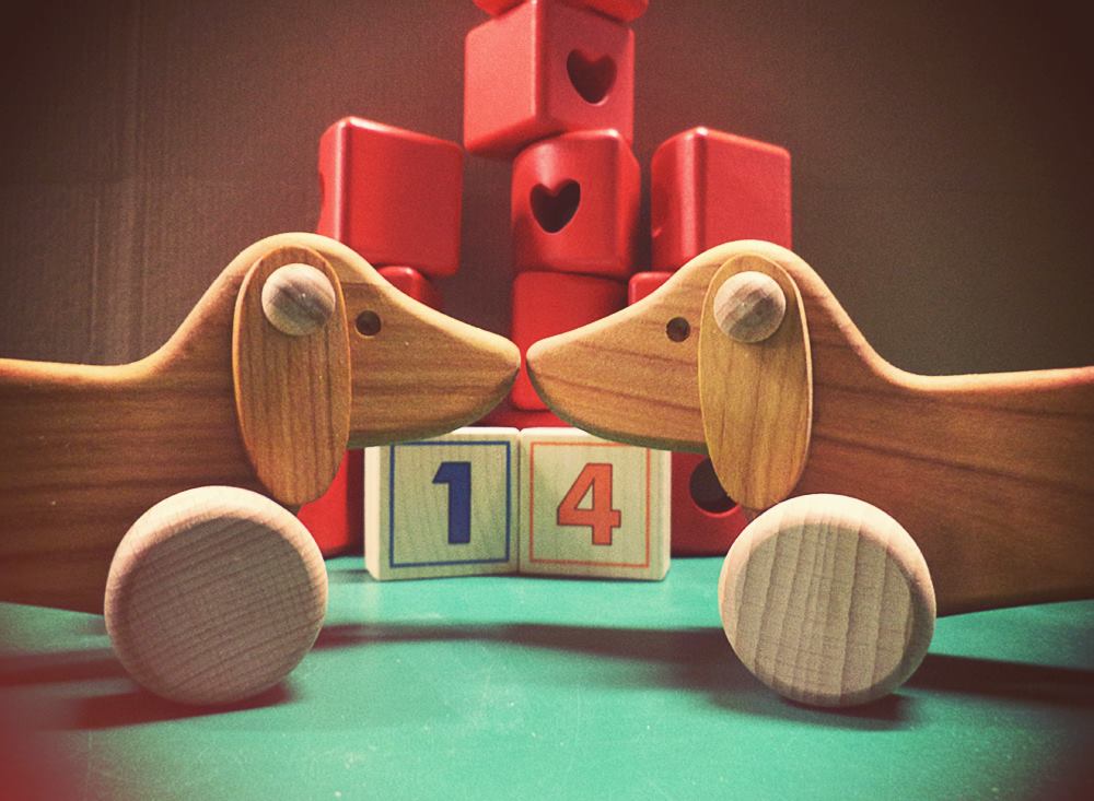 Bajo dachshunds with noses rubbing together.  Red heart cut-out blocks and number blocks in background.