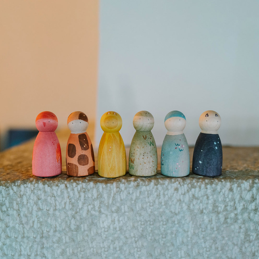 Grapat peg people wooden toys with animal prints on fireplace ledge