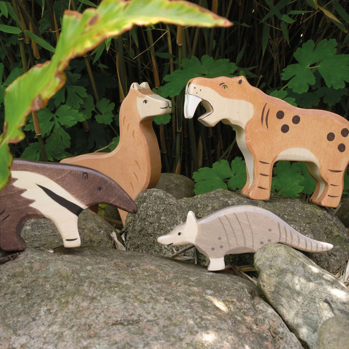 Holztiger wooden animal toys on rocks with a natural background