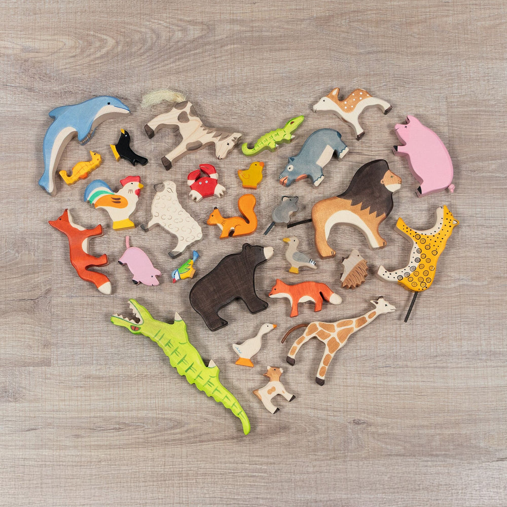 Holztiger animal figures flat layed in the shape of a heart