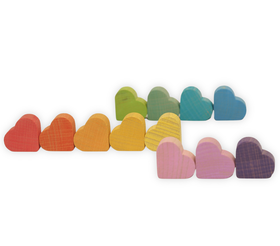 Row of colorful Ocamora wooden hearts on a white background