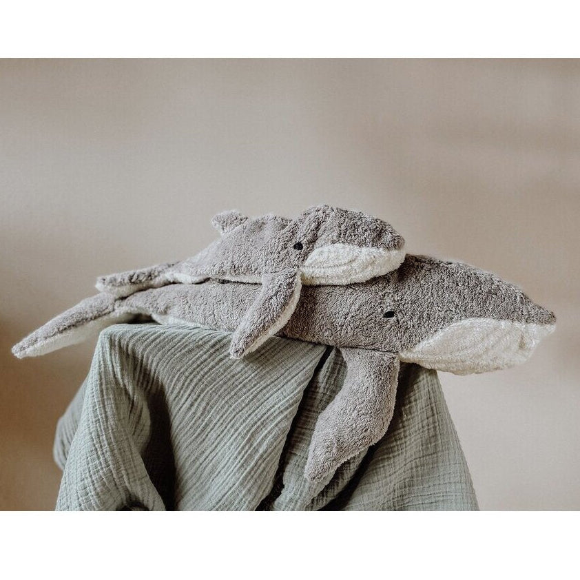 Organic cotton grey whale stuffed animals on a soft fabric background