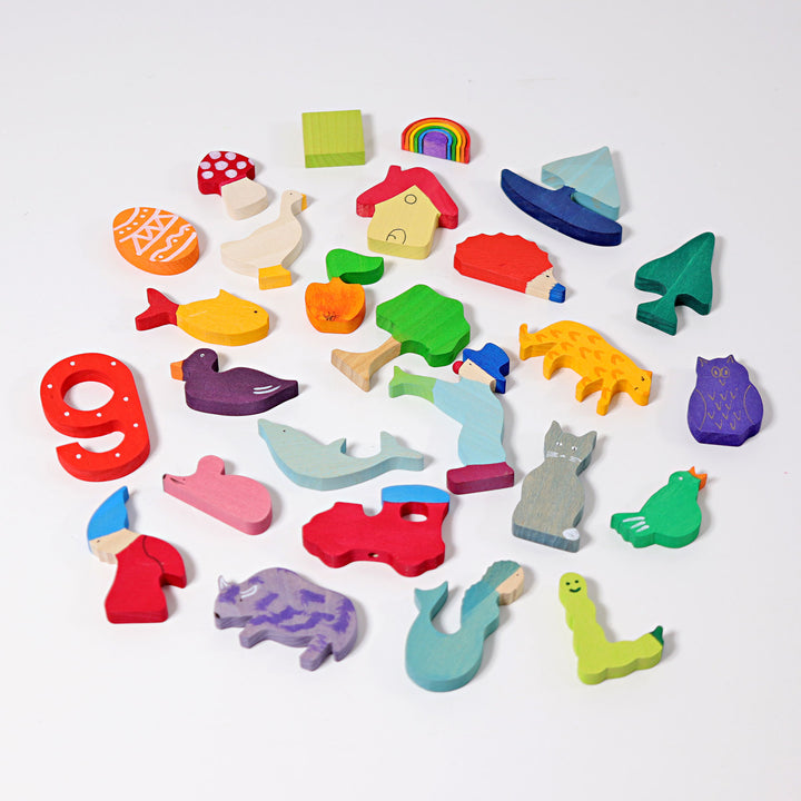 A collection of colorful hand-painted wooden figures shaped as letters and animals, intended for educational and therapeutic use.